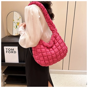 Detail of hot pink quilted cloud tote bag featuring a textured puffy shoulder strap