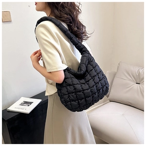 Close-up of a black quilted cloud bag showing wide comfortable shoulder strap and texture
