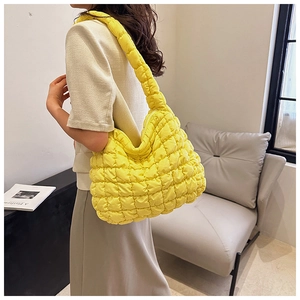 Detail of quilted puffy shoulder bag with ruched texture and soft yellow nylon fabric