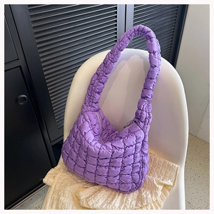 Macro detail of purple quilted bubble fabric and zipper on the soft cloud shoulder bag