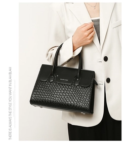 Detail of black woven leather tote bag featuring Balado & Bao logo and silver zipper