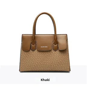 Detail of khaki tote bag featuring smooth leather and crocodile pattern texture mix