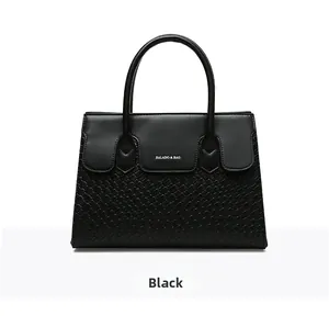 Close-up of black woven texture and smooth leather finish on a large tote bag