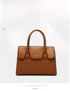 Detail of brown woven faux leather tote with smooth flap and circular top handle