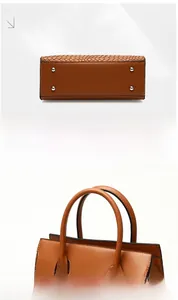 Detail view of brown woven tote bag showing base with studs and reinforced handles