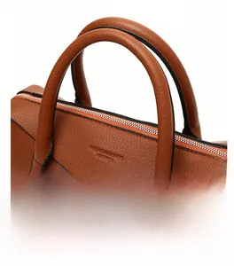 Gros plan du sac à main en cuir caramel avec deux poignées et détails de grande capacité