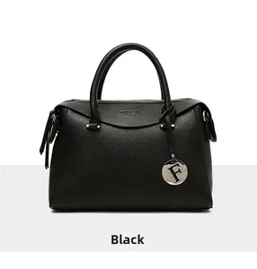 Gros plan du sac à main en cuir grainé noir avec pendentif lettre F en métal argenté