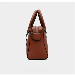 Détail d'un sac à main en cuir marron avec anneau en D et fermeture éclair argent