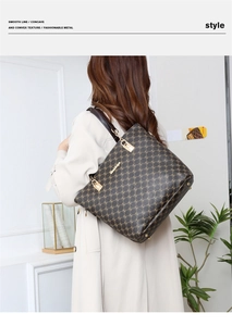 Détail d'un sac cabas marron à monogramme avec boucle dorée brillante et poignée en cuir