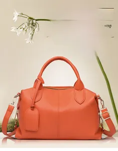 Dettaglio della borsa Boston arancione in pelle litchi con cuciture verticali e manici