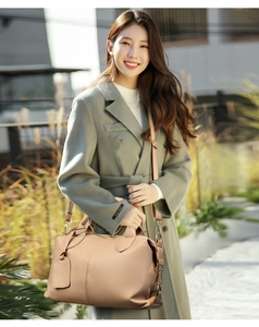 Borsa Boston marrone chiaro abbinata a un cappotto grigio in un contesto outdoor