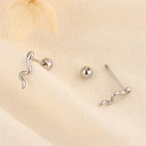 Macro shot of silver snake earrings with zircon eyes and threaded screw back closure