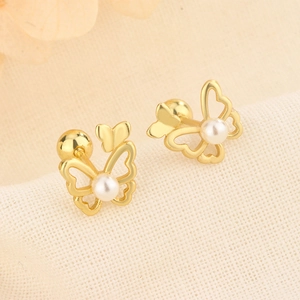 Macro detail of butterfly pearl earrings with gold hollow wings and secure screw back
