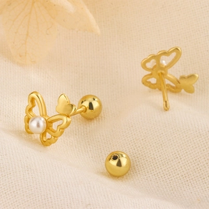 Macro detail of asymmetric butterfly pearl studs with secure screw back closure