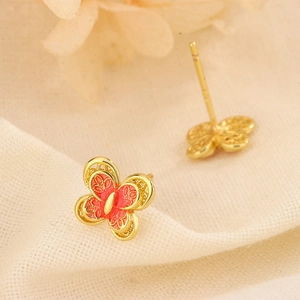 Macro detail of S925 butterfly earrings with red enamel and 18K gold hollow frame