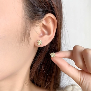 Sparkling four-leaf clover stud earrings with pavé crystals on a gold metal base for women