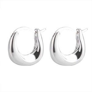 Macro detail of silver thick U-shaped hoop earrings with polished metallic surface