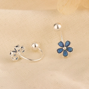 Blaue Zirkonia Blumenohrringe mit silbernem C-Haken und Schraubverschluss auf beigem Stoff