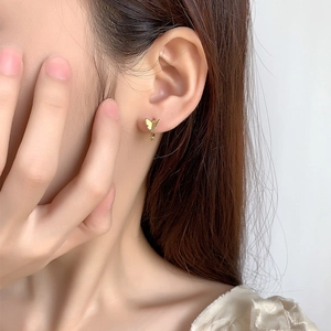 Elegant 18K gold butterfly hoop earring shown on ear for a minimalist jewelry style