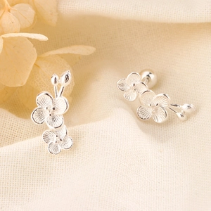 Macro view of S925 silver plum blossom stud earrings with secure screw back design