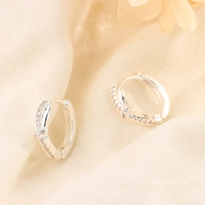 Detailed macro shot of S925 sterling silver knotted hoop earrings with clear cubic zirconia