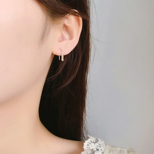 Close-up of minimalist silver water-drop ear hook with liquid metal wave texture