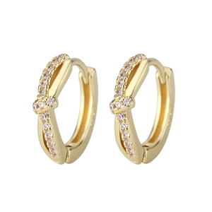 Close-up of golden knotted cross hoop earrings with pave pink cubic zirconia stones