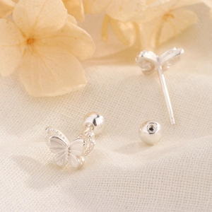 Detailed macro shot of silver butterfly stud earrings with secure ball screw backs