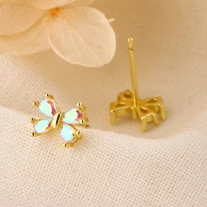 Gros plan détaillé des boucles d'oreilles papillon en opale rose avec placage à l'or