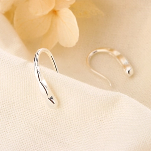 Minimalist silver geometric drop earrings with hammered texture on linen background