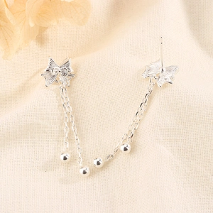 Detailed view of silver bow-knot tassel earrings with delicate hollow filigree craftsmanship