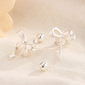 Macro view of silver bow earrings with star pendant and secure screw back closure