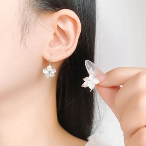 Elegant S925 silver flower stud earrings with center diamond on female model ear