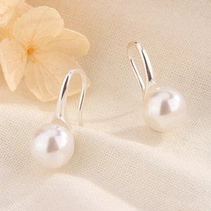Boucles d'oreilles élégantes en perles d'eau douce sur tissu texturé minimaliste