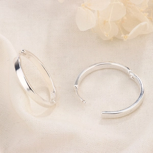 Macro shot of minimalist S925 sterling silver hoop earrings with polished finish
