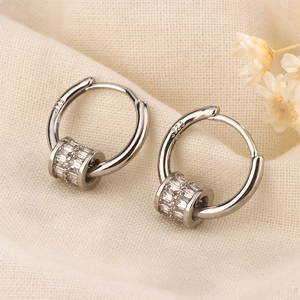 Detail of S925 silver hoop earrings with cylinder pendants and micro-pave zircons