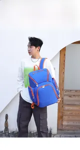 Detailed view of water-resistant blue oxford backpack with contrast orange zippers