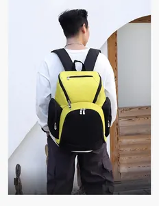 Rear view of yellow and black waterproof fitness backpack worn by model against a white wall