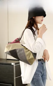 Detail showing high-capacity patchwork canvas tote bag with leather straps and rivets