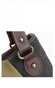 Close-up of canvas tote bag handle with leather strap, metal D-ring and white stitching