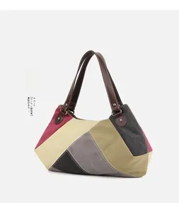Close-up of a large multi-colored canvas tote bag featuring premium leather handles