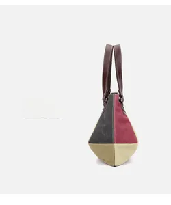 Detailed side view of the tricolor canvas tote with leather handles and metal rivets
