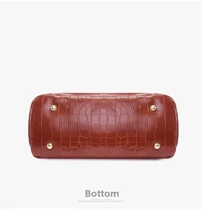 Vue détaillée du fond du sac en similicuir avec texture crocodile et pieds dorés