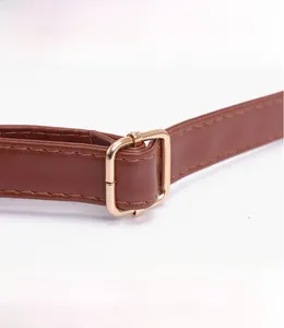 Détail d'une bandoulière réglable en cuir PU marron avec boucle en métal doré