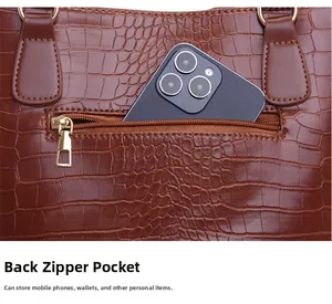 Détail de la poche zippée arrière d'un sac cabas marron à texture crocodile pour téléphone