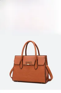 Detail of orange tote bag featuring crocodile pattern leather and metal clasp