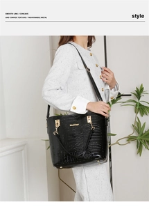 Détail du sac à main noir montrant la texture crocodile brillante et les ferrures dorées