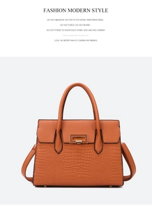 Detailed view of crocodile pattern tote bag with golden metal buckle and shoulder strap