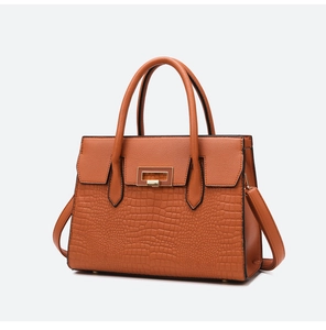 Detail of orange tote bag with mix of lychee grain and crocodile textured faux leather