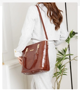 Détail du sac cabas marron à motif crocodile avec garniture dorée et logo de marque